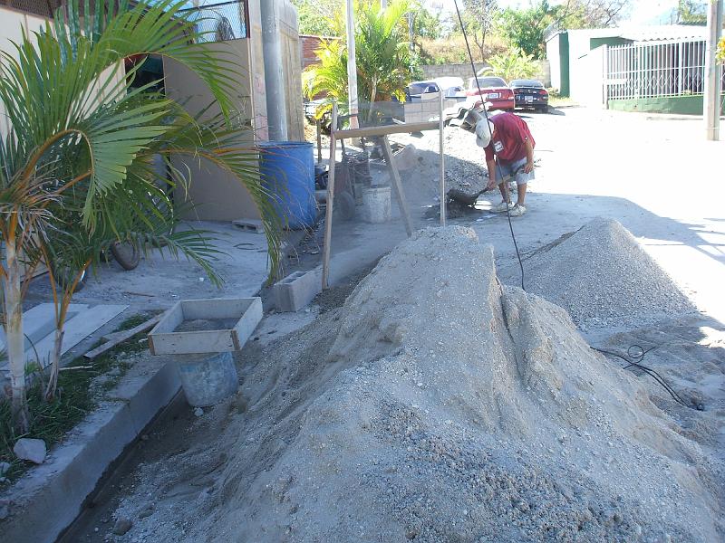 DSCF2126.JPG - It seems to be common practice to leave the rock and san piles in the street.  I've seen it with other projects.  As you can see, there isn't much of a yard or driveway to work with.  People in the neighborhood seem ok with this unless you block more than half the street.  We got a visit one day from the police due to a neighbor complaining about just that.  We asked the workers to be careful about leaving room for traffic and had no further trouble.